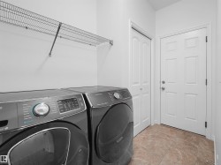Laundry area with tile flooring, wire shelving, and two paneled doors - 