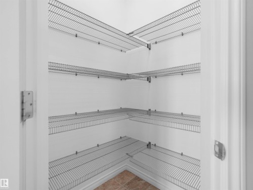 Interior closet featuring multiple wire shelving units, white walls, and a light-toned tile floor - 2017 32A Street, Edmonton, AB - Indoor With Storage