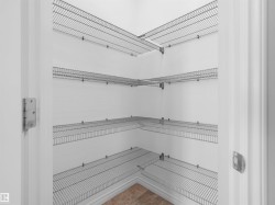 Interior closet featuring multiple wire shelving units, white walls, and a light-toned tile floor - 