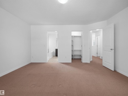 Spacious room featuring neutral carpeting, white walls, and bright overhead lighting - 2017 32A Street, Edmonton, AB - Indoor Photo Showing Other Room