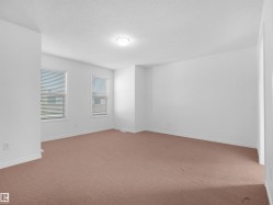 Spacious interior room featuring light-colored walls and wall-to-wall carpeting - 