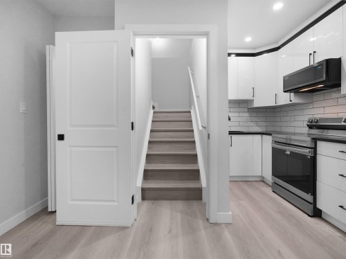 Modern kitchen featuring white cabinetry, subway tile backsplash, and stainless steel appliances - 2017 32A Street, Edmonton, AB - Indoor Photo Showing Kitchen