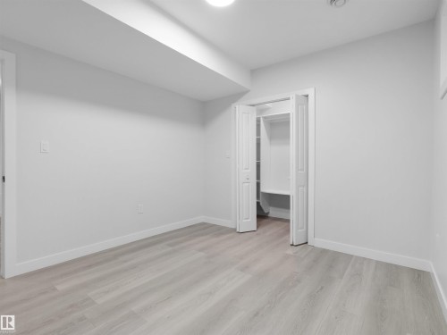 Spacious room featuring light wood-finish flooring, white walls, and bright baseboards - 2017 32A Street, Edmonton, AB - Indoor Photo Showing Other Room