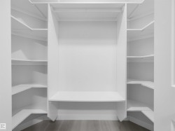 Custom closet system featuring white shelving and a built-in hanging rod - 