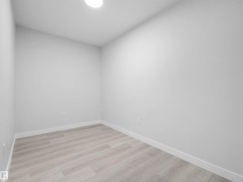 Interior room featuring light wood-finish flooring, white baseboards, and light gray walls - 2017 32A Street, Edmonton, AB - Indoor Photo Showing Other Room