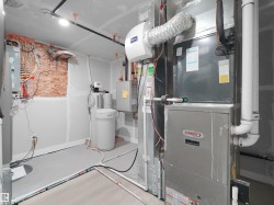 Utility area featuring a Lennox furnace, water heater, water softener, and electrical panel - 