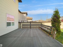 Expansive composite deck featuring built-in bench seating and perimeter fencing - 