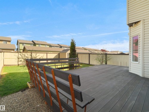 Private backyard featuring a spacious deck with a built-in railing, a manicured lawn, and a light-toned privacy fence - 2017 32A Street, Edmonton, AB - Outdoor With Exterior