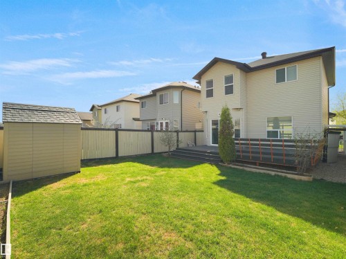 Expansive backyard featuring a manicured lawn, a detached storage shed, a multi-level deck, and a privacy fence - 2017 32A Street, Edmonton, AB - Outdoor
