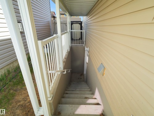 Concrete exterior stairs with white metal railings provide access to the lower level - 2017 32A Street, Edmonton, AB - Outdoor With Exterior