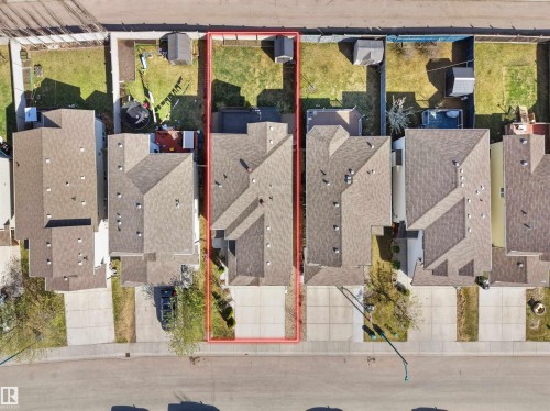 Aerial perspective showcasing a residential property with a multi-car driveway, a pitched roof, and a fenced backyard - 2017 32A Street, Edmonton, AB - 