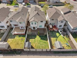 Two-story residential property featuring a large backyard with a wooden fence - 