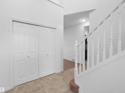 Entryway featuring light-toned tile flooring and white bi-fold closet doors - 