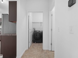 Dedicated laundry area featuring a front-load appliance, overhead shelving, and tiled flooring - 