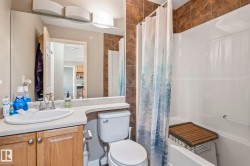 Bathroom featuring a single vanity with wood-finish cabinetry, a white countertop, and an integrated sink - 