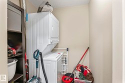 Dedicated laundry area featuring a stacked washer and dryer unit - 