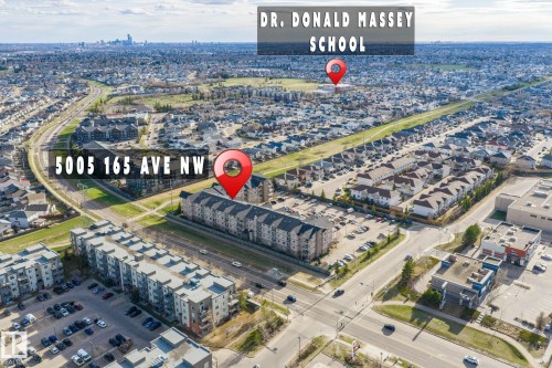 Aerial overview of the surrounding area featuring residential buildings, commercial structures, and local roadways - 412 5005 165 Avenue Nw, Edmonton, AB - Outdoor With View