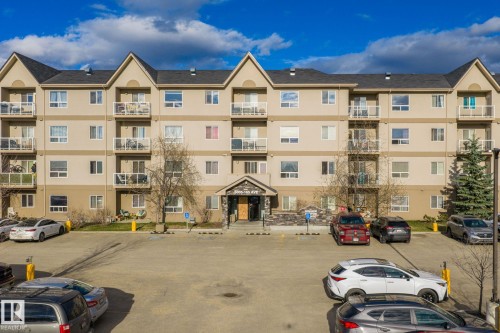 Multi-story residential building with light-colored exterior siding and dark roofing - 412 5005 165 Avenue Nw, Edmonton, AB - Outdoor With Balcony With Facade