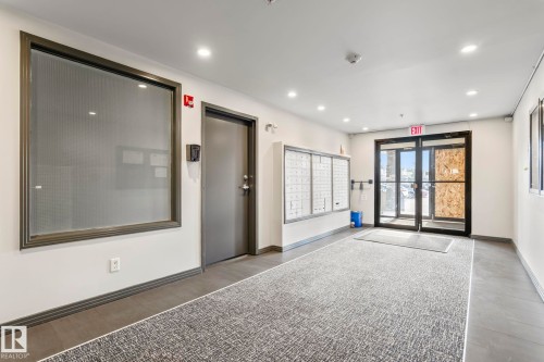 Building entrance featuring commercial-style glass doors, wall-mounted mailboxes, recessed lighting, and a textured area rug - 412 5005 165 Avenue Nw, Edmonton, AB - Indoor Photo Showing Other Room