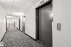 Hallway with patterned carpeting, recessed lighting, and white walls - 