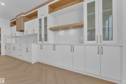Custom cabinetry featuring integrated wood-finish shelving and glass-front doors - 12 Dalquist Bay, Leduc, AB - Indoor Photo Showing Other Room