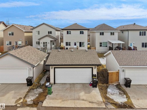 Rear detached garage featuring a white overhead door and light-colored siding - 5192 1B Ave Sw, Edmonton, AB - Outdoor