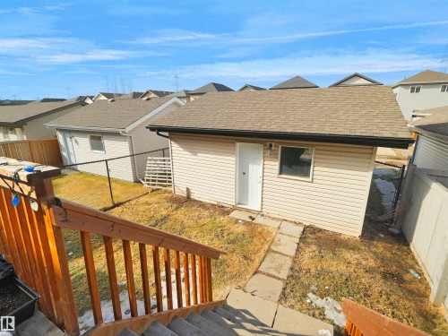 Detached outbuilding with light-colored siding, a brown shingle roof, and a single window - 5192 1B Ave Sw, Edmonton, AB - Outdoor With Exterior