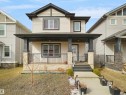 Two-story residence featuring light-colored siding with dark trim accents - 5192 1B Ave Sw, Edmonton, AB  - Outdoor With Deck Patio Veranda With Facade 