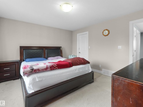 Bedroom featuring neutral wall paint, white trim, recessed baseboards, and a flush-mount ceiling light fixture - 5192 1B Ave Sw, Edmonton, AB - Indoor Photo Showing Bedroom