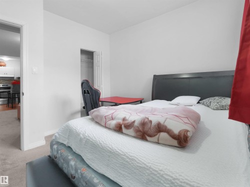 Bedroom featuring light gray wall paint, carpeting, and a built-in closet with an open door - 5192 1B Ave Sw, Edmonton, AB - Indoor Photo Showing Bedroom