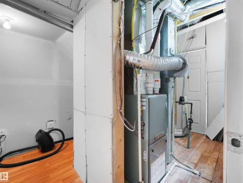 Mechanical room with a furnace unit, exposed ductwork, and partially finished drywall - 5192 1B Ave Sw, Edmonton, AB - Indoor