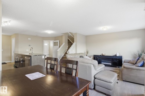 Open-concept living space featuring light-toned walls and wood-finish flooring - 893 Ebbers Crescent Nw, Edmonton, AB - Indoor Photo Showing Living Room
