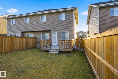 Spacious backyard featuring a wooden deck with steps, a manicured lawn, and privacy fencing - 893 Ebbers Crescent Nw, Edmonton, AB - Outdoor With Exterior