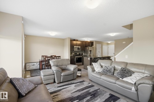 Open-concept living area featuring light-toned walls, wood-finish flooring, and recessed lighting - 893 Ebbers Crescent Nw, Edmonton, AB - Indoor Photo Showing Living Room