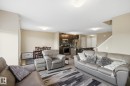 Open-concept living area featuring light-toned walls, wood-finish flooring, and recessed lighting - 893 Ebbers Crescent Nw, Edmonton, AB  - Indoor Photo Showing Living Room 