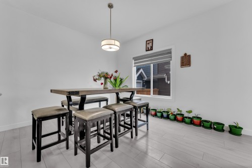 Bright interior space featuring light wood-finish flooring, white walls, and a contemporary ceiling fixture - 1645 Plum Circle Circle, Edmonton, AB - Indoor Photo Showing Dining Room