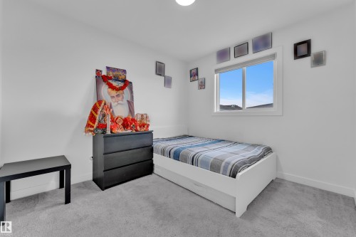 Bright interior space featuring a single window with white trim, light gray carpet flooring, and clean white walls - 1645 Plum Circle Circle, Edmonton, AB - Indoor Photo Showing Bedroom