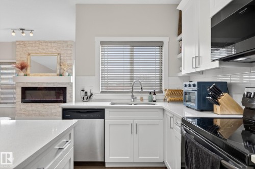 94 Tribute Common, Spruce Grove, AB - Indoor Photo Showing Kitchen With Fireplace With Double Sink