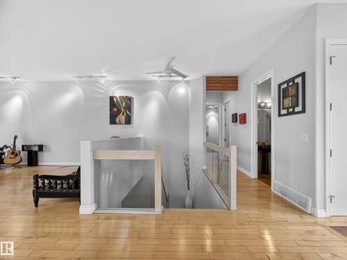 Bright interior space featuring wood-finish flooring, a contemporary ceiling fan, and track lighting - 569 Butterworth Way, Edmonton, AB - Indoor Photo Showing Other Room