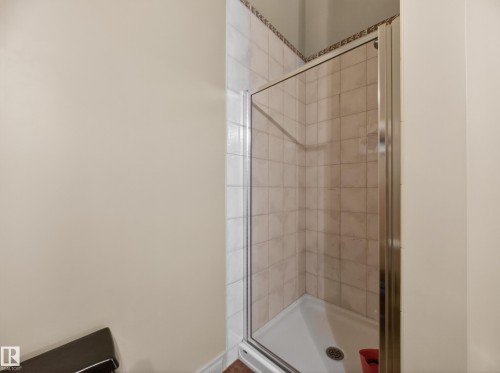Enclosed shower stall featuring tiled walls with a decorative border and a white shower base - 569 Butterworth Way, Edmonton, AB - Indoor Photo Showing Bathroom