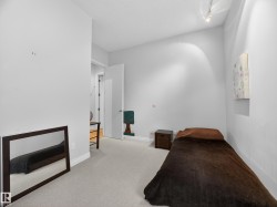 Carpeted room featuring light gray walls, white trim, and a white interior door - 