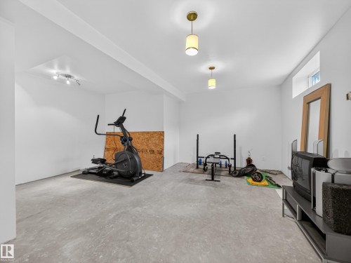 Spacious lower level featuring painted walls, concrete flooring, and ceiling-mounted light fixtures - 569 Butterworth Way, Edmonton, AB - Indoor