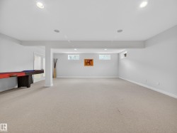 Spacious finished room featuring light neutral carpeting, recessed ceiling lighting, and multiple windows - 