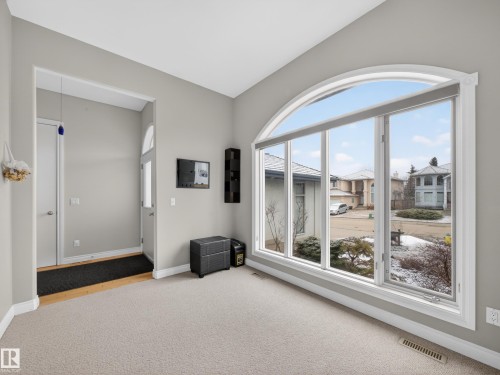 Arch-top window with multi-pane design and white trim - 569 Butterworth Way, Edmonton, AB - Indoor Photo Showing Other Room