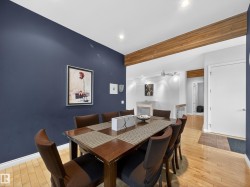 Dining area featuring a dark accent wall, wood-finish flooring, and recessed lighting - 