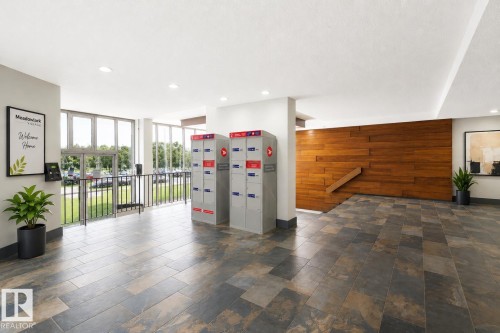 Lobby featuring slate tile flooring, a wood-paneled accent wall, and recessed lighting - 90 8745 165 Street, Edmonton, AB - Indoor