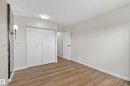 Spacious room featuring wood-finish flooring, white walls, and a ceiling-mounted light fixture - 90 8745 165 Street, Edmonton, AB  - Indoor Photo Showing Other Room 