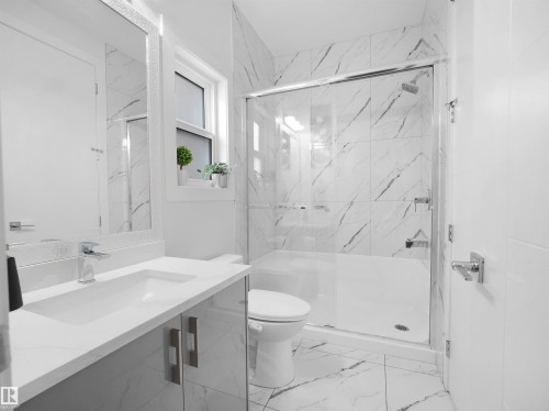 Modern bathroom featuring a single vanity with an integrated sink and chrome faucet - 1208 25 St Nw, Edmonton, AB - Indoor Photo Showing Bathroom