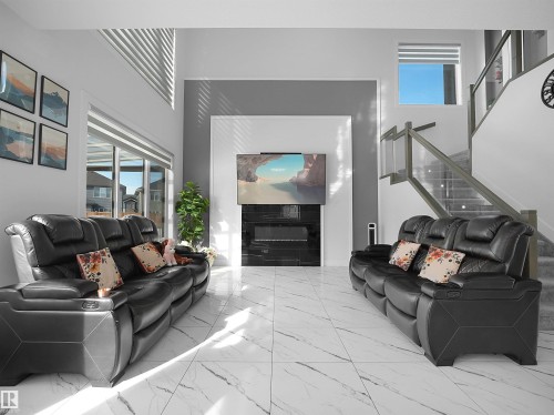 Spacious living area featuring large format white marble-look tile flooring - 1208 25 St Nw, Edmonton, AB - Indoor
