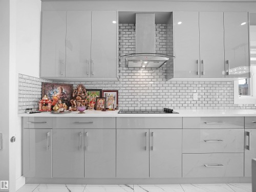 Modern kitchen featuring sleek grey cabinetry, white subway tile backsplash, and light-toned countertops - 1208 25 St Nw, Edmonton, AB - Indoor Photo Showing Kitchen